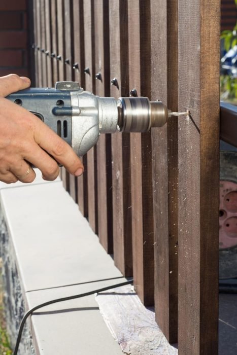 man-hands-drilling-wooden-fence-metal-construction-building-wooden-fence-with-drill-screw-close-up-his-hand-tool-diy-concept_635416-2019